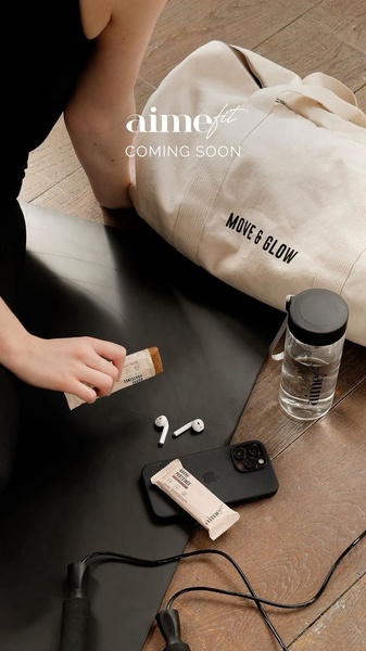 A top-down lifestyle shot showing a protein bar, yoga mat, gym bag, and fitness accessories on a wooden floor.